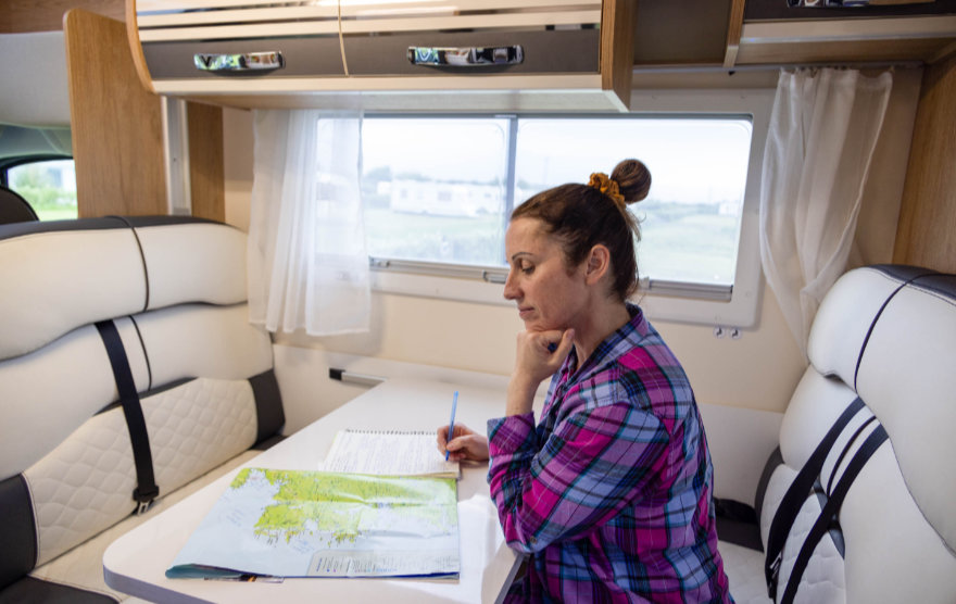 A motorhome driver planning a route with a map before following UK speed limits and road rules